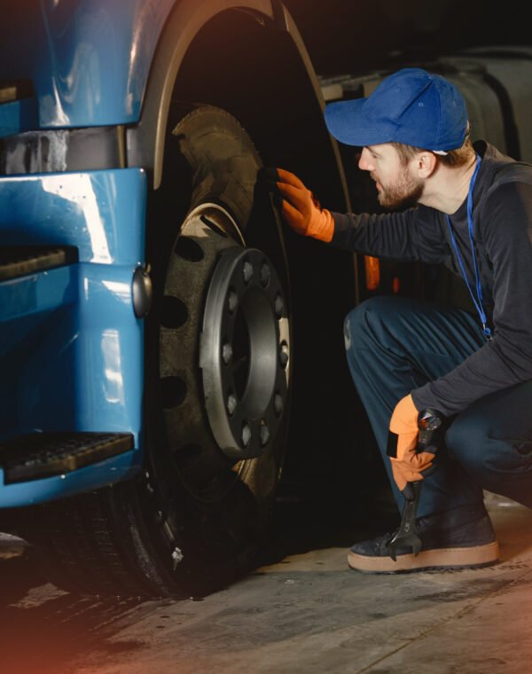 A young worker checks wheel. Truck malfunction. Service work.